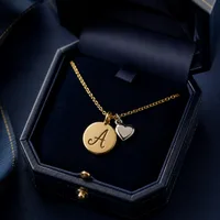 Collar de oro con inicial grabada en su estuche